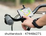 Close-up Of Human Hand Pointing At Smart Phone Showing GPS Navigation On Bicycle