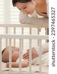 Small photo of Young mother coaxing baby to sleep