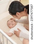 Small photo of Young mother coaxing baby to sleep