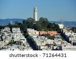 Coit Tower and the Bay Bridge as viewed from the intersection of Lombard & Hyde Street in San Francisco, California