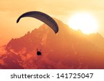 Sepia paraglide silhouette over Alps peaks