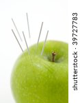 Small photo of A green apple used to demonstrate the use of Acupuncture needless