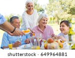 Small photo of Extended family eating outdoors