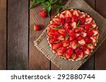 Tart with strawberries and whipped cream decorated with mint leaves. Top view
