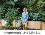 Small photo of Blond woman harvesting mangold from her raised bed in her own garden
