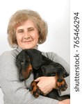 Small photo of Elderly woman sits and embosom dachshund
