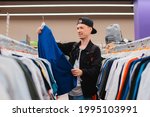 Small photo of Portrait smiling modern young hipster man 25-35 years old cap shopping at mens store clothes, clothing, garment, raiment, garb