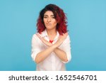 Never, no compromise! Portrait of dissatisfied hipster woman with fancy red hair crossing hands, showing x sign, ban or prohibition gesture, rejecting offer. studio shot isolated on blue background