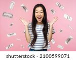 Small photo of Oh my god, wow. Portrait of amazed young woman looking at camera with big eyes, absolutely shocked of money rain falling from up. indoor isolated on pink background