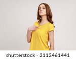 Small photo of This is me! Portrait of egoistic haughty brown haired female of young age in casual attire pointing herself with superiority, proud of achieved goal. Indoor studio shot isolated on gray background.