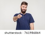 Small photo of Jibe, bad taunt concept. Young adult man pointing finger and toothy smile. Studio shot, gray background