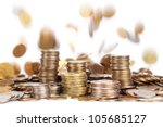 stacks of silver and golden coins and falling coins on background isolated