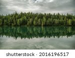 Glacial Lake and the Spruce Forest Line Scenic Nature Symmetrical Alignment Water Reflections. Nordland Norway.