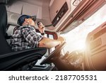 Small photo of Caucasian Middle Aged Truck Driver Talking Via Citizen Band Radio During Completing a Delivery of His Cargo. Side View Photo Inside the Lorry Cabin. Transportation Industry Theme.