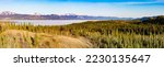 Hi-res panoramic landscape view of still frozen ice-covered Lake Laberge in spring May boreal forest tiaga of Yukon Territory, Canada