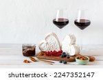 Heart shape cheese served with berries and two red wine glasses, Valentine Day