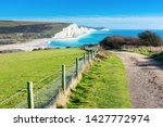 Walk in Cuckmere Haven near Seaford, East Sussex, England. South Downs National park. View of blue sea, cliffs, beach, green fields, selective focus
