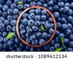 Fresh blueberry with drops of water in wooden bowl. Top view. Concept of healthy and dieting eating