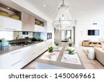 Kitchen with adjoining snack counter set for four people and living area with a wall hanging T.V.