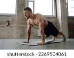 Young athletic man doing push...