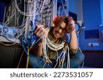 Small photo of Crazy mad computer engineer wrapped in wires and cables in server room
