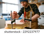 Small photo of Young male jointer fixing wooden construction or assembling of furniture