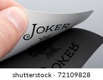 Close-up of Joker card in palm of hand