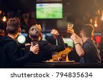 Three men watches football on TV in a sport bar