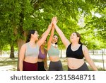 Excited group of diverse women doing a high five celebrating finishing their run together or exercises promoting body acceptance 