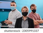 Small photo of A group of colleagues stand ingin a robotics laboratory, arms crossed, wearing protective masks, symbolizing their teamwork and commitment to technological innovation and scientific research.