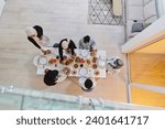 Small photo of Top view of a Muslim family joyously comes together around a table, eagerly awaiting the communal iftar, engaging in the preparation of a shared meal, and uniting in anticipation of a collective
