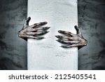 A Pair of Scary Hands Reach Out from Behind a COlumn