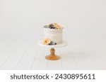 natural white cake with blueberry floral garnish