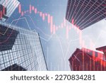 Investing, trading and real estate market crisis concept with digital red financial chart candlestick and graphs on modern skyscraper tops bottom view background, double exposure