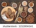 High fibre natural health food with whole wheat pasta, whole grain rye bread, oatmeal, oats, bran flakes and wheat sheath on lokta paper background.  