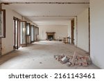 Small photo of Large bright room with many windows of an old villa undergoing demolition and renovation. The walls have been knocked down and the floor is gone. Nobody inside