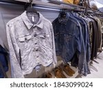 .blue jeans jacket on the hanger . Blue jeans jacket with different shirt for sale in the mall



