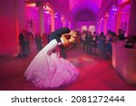 Small photo of first dance - Elegant wedding by night. Groom kisses the bride in a waltz