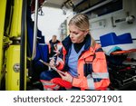 Small photo of Young rescuer doctor checking equipment in ambulance car.