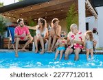 Small photo of Multi generation family enjoying summer time, sitting at backyard pool.