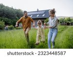 Small photo of Family walking near their house with photovoltiacs panels on the roof.