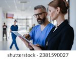 Small photo of Pharmaceutical sales representative talking with doctor in medical building. Ambitious female hospital director consulting with healtcare staff. Woman business leader.