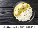 Small photo of Traditional recipe for Danish Meatballs in Curry Boller i Karry with rice garnish close up in the plate on the table. horizontal top view from above