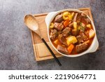 Small photo of Traditional Irish Stew featuring succulent lamb, sweet root vegetables, and an irresistibly rich broth closeup in the pot on the table. Horizontal top view from above