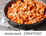 Small photo of Creamy casserole Flygande Jakob made of chicken, cream, chilli sauce, bananas, roasted peanuts and bacon closeup on the pan on the table. Horizontal