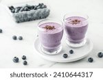 Small photo of Glasses of fresh homemade blueberry smoothie with cacao nibs.