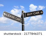 Small photo of Lease vs Buy. Two street signs with arrow on metal pole with word. Directional road. Crossroads Road Sign. Two Arrow. Blue sky background. Concept for own property versus borrow it