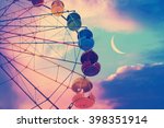 Vintage photo with ferris wheel against the moon colorful sky 