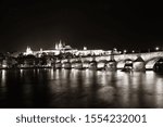 Prague skyline and bridge over river in Czech Republic at night.