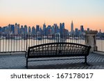 Bench in park and New York City midtown Manhattan at sunset with skyline panorama view over Hudson River